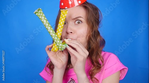 Funny woman celebrating birthday and hooting with horn photo