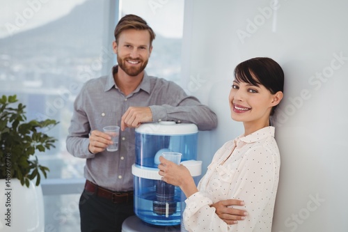 Portrait of smiling executives holding glasses of water