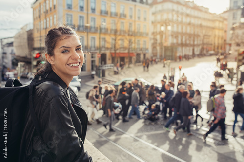 Young traveler woman admiring beautiful sunny Praca de Luis Camoes square in Lisbon, Portugal.Sunny day in Lisbon, perfect place for traveling in Europe.Crowded Lisbon streets.Backpacker photographer