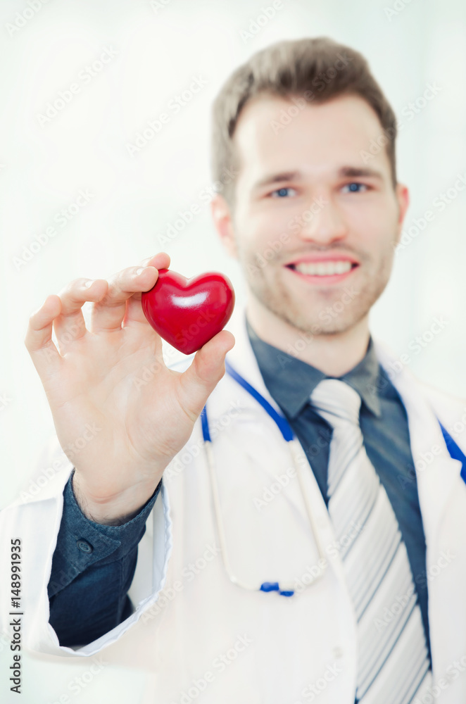 Doctor holds a heart shaped model in his hand Doctor holds a heart shaped model in his hand