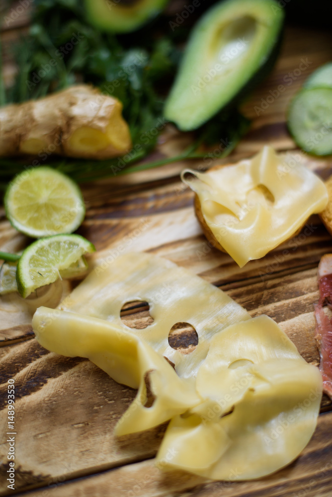 Vegetables ginger lime avocado cut in two pisces cucumber parsley leeks cheese croutons toast on wooden background