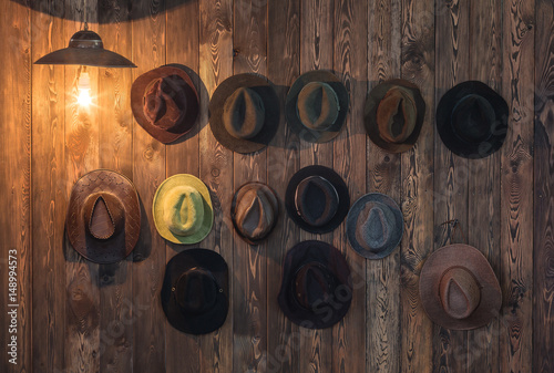 Old hats hang on a wooden wall