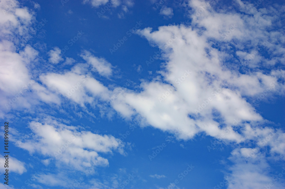 Beautiful deep blue sky with white clouds at sunny day. Abstract natural background with thick fluffy clouds Beautiful deep blue sky with white clouds at sunny day. Abstract natural background with thick fluffy clouds