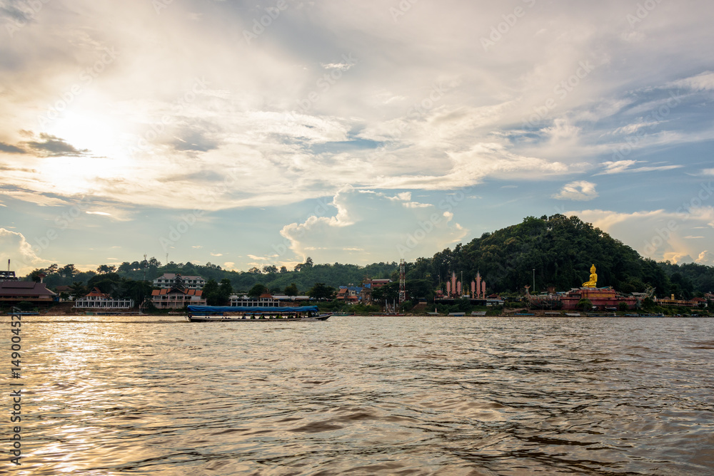 Beautiful natural landscape and tourist boat cruising the beauty of the Mekong River coast at sunset in the Golden Triangle Park (Sob Ruak) in Chiang Rai Province, Thailand