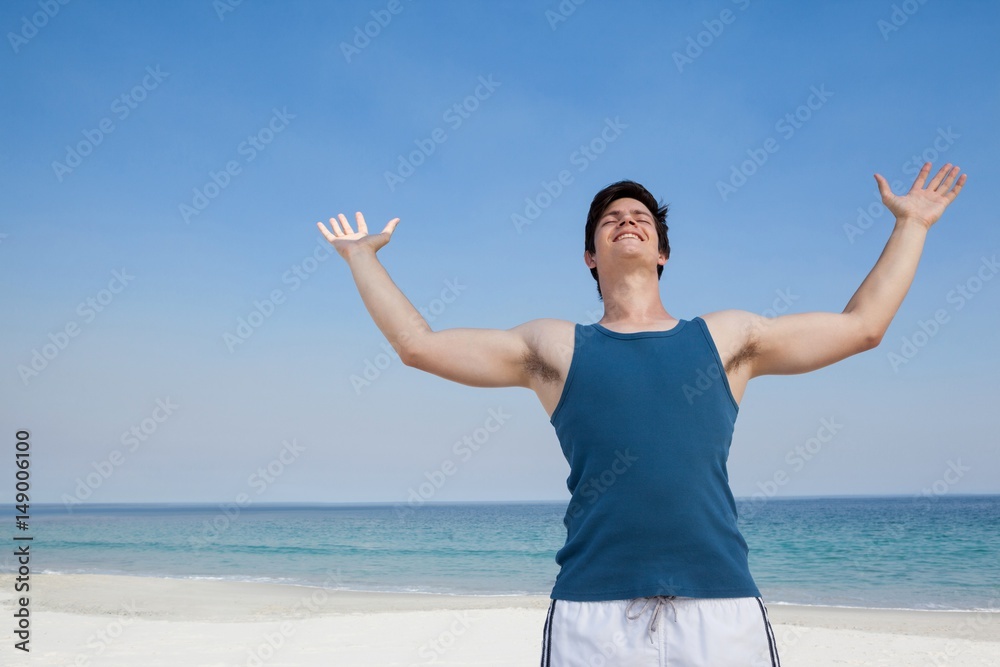 Man standing at beach with arms outstretched Man standing at beach with arms outstretched