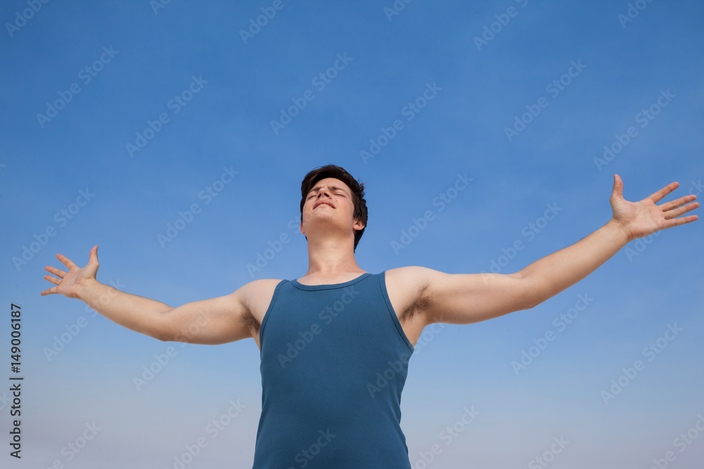 Man standing at beach with arms outstretched Man standing at beach with arms outstretched
