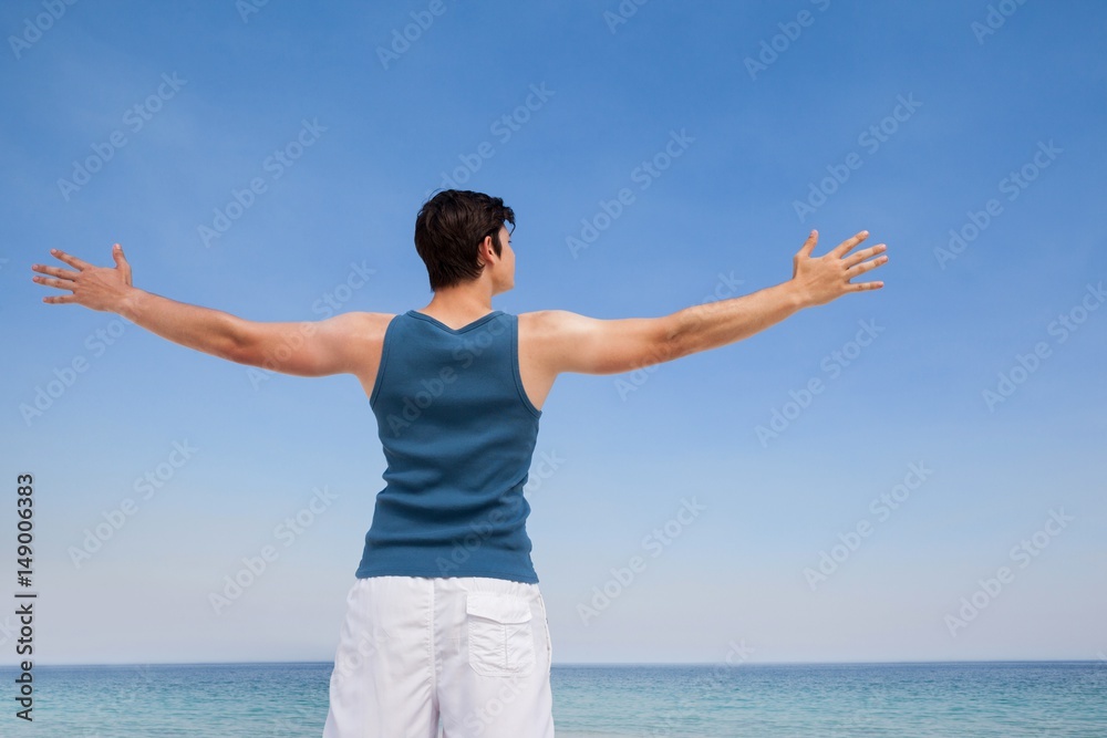 Man standing at beach with arms outstretched Man standing at beach with arms outstretched
