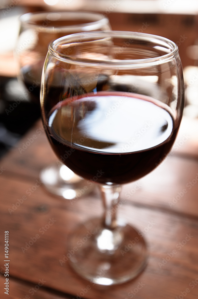 Two glasses of red wine on the vibrant restaurant background. Selective focus.