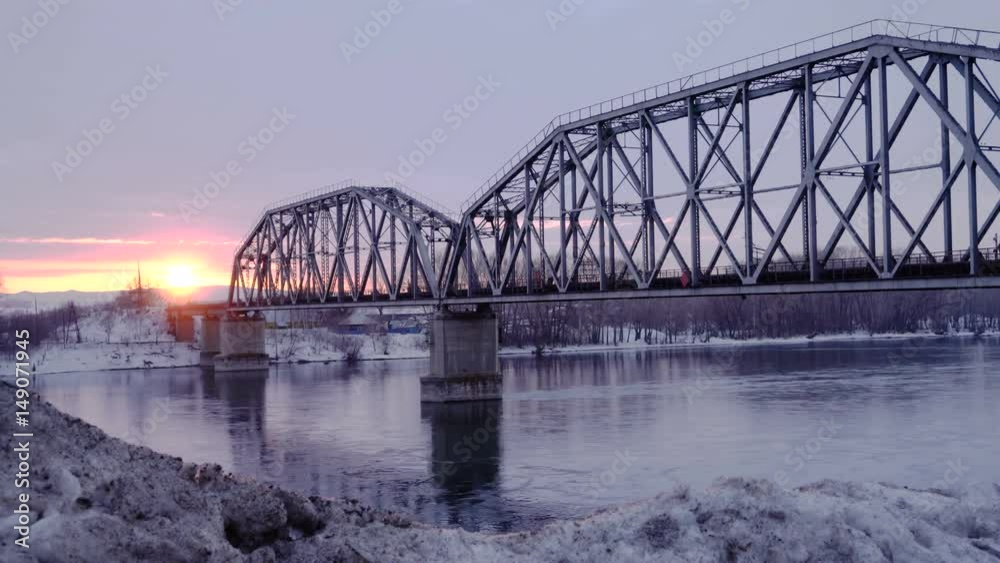 Time lapse of railway bridge over the river at dawn with a mountain forest and traffic highway in the background. Time lapse of railway bridge over the river at dawn with a mountain forest and traffic highway in the background.