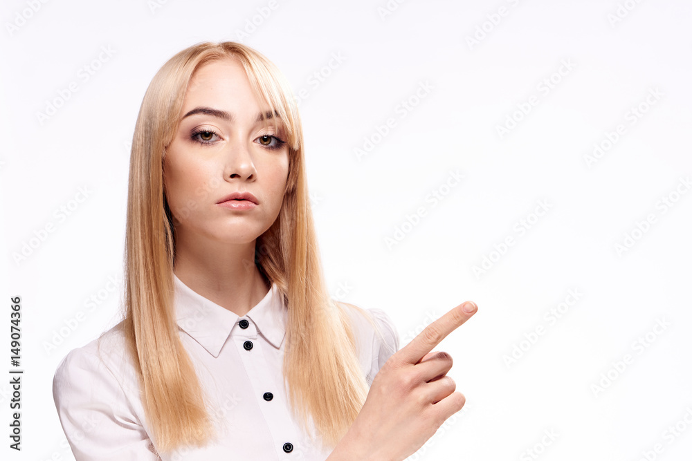 woman showing forefinger to the side, light background woman showing forefinger to the side, light background