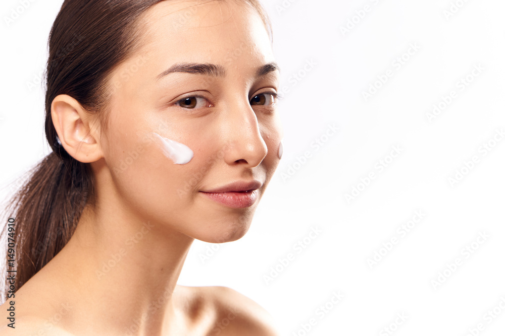 brunette with dark eyebrows and moisturizer on her face