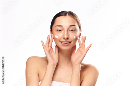 moisturizer on the face of a young woman, dark hair