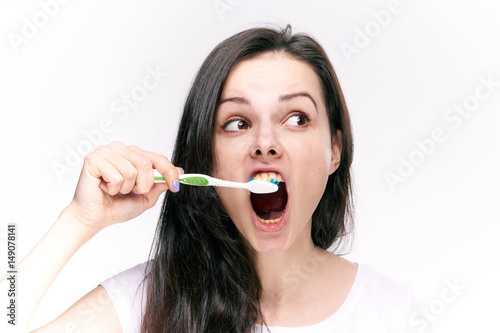 beautiful woman in a light t-shirt brushes teeth