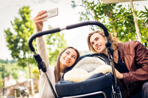 Young Parents Taking Selfies With Their Newborn Baby