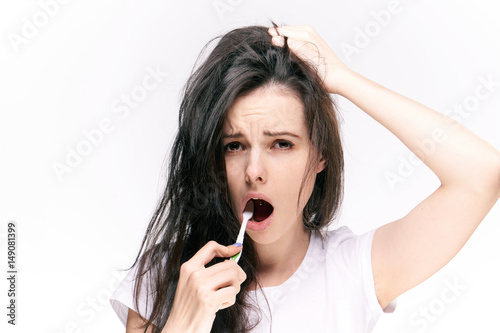 woman with tangled hair brushes teeth