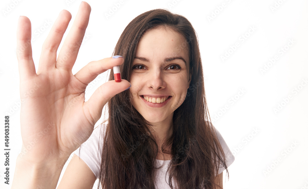 woman with a wide smile showing a pill woman with a wide smile showing a pill