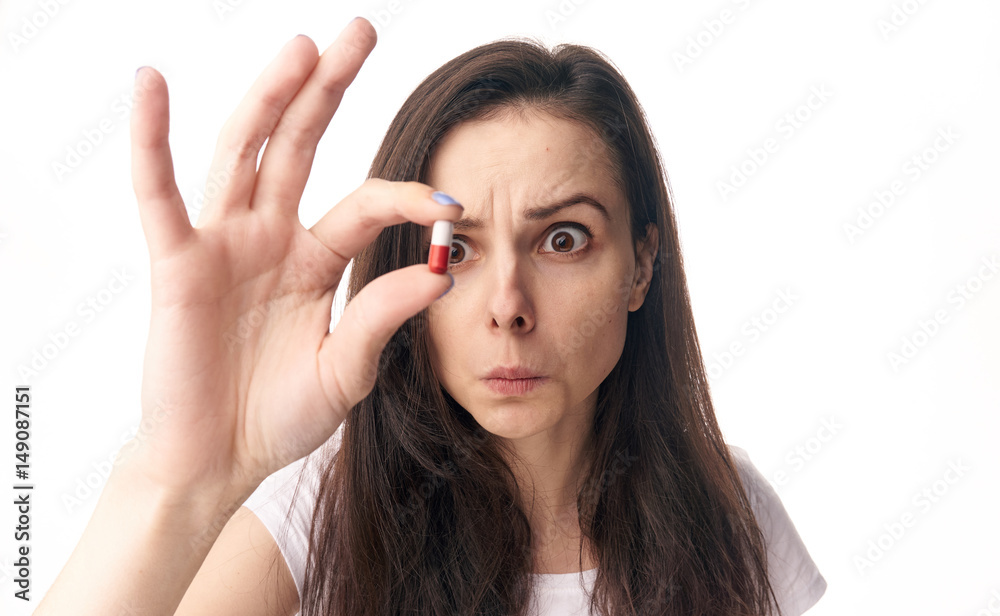 interested woman looks at pill interested woman looks at pill