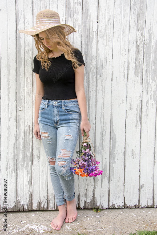 teen girl in frayed blue jeans with daisy bouquet by whitewashed barn Stock  Photo | Adobe Stock