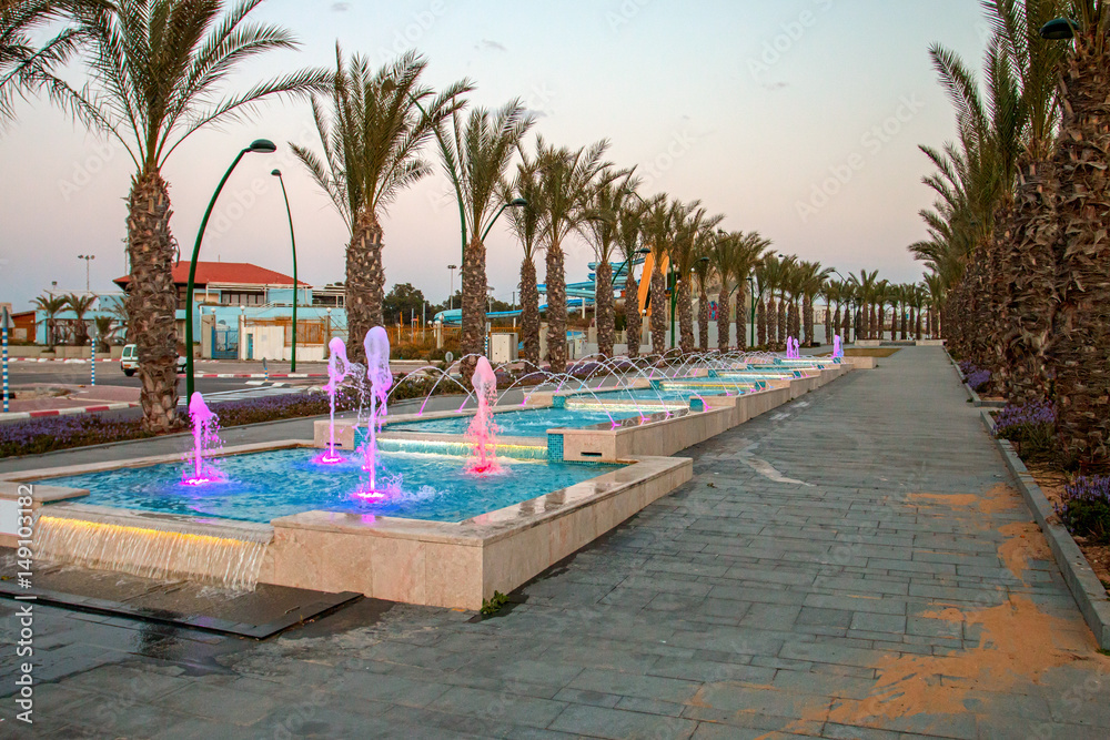 Obraz premium Ashkelon seaside park fountains colored evening light