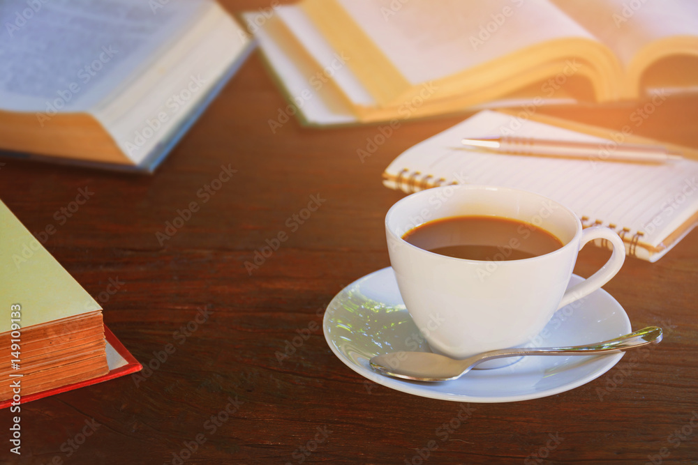 Obraz premium Coffee mug and book on old wooden table