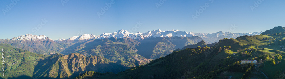Drone aerial view to the Orobie Alps and Formico pick in a clear and blue day. Fresh snow on the top of mountain in spring. Panorama at Farno Mountain, Bergamo, Italy. Drone aerial view to the Orobie Alps and Formico pick in a clear and blue day. Fresh snow on the top of mountain in spring. Panorama at Farno Mountain, Bergamo, Italy.
