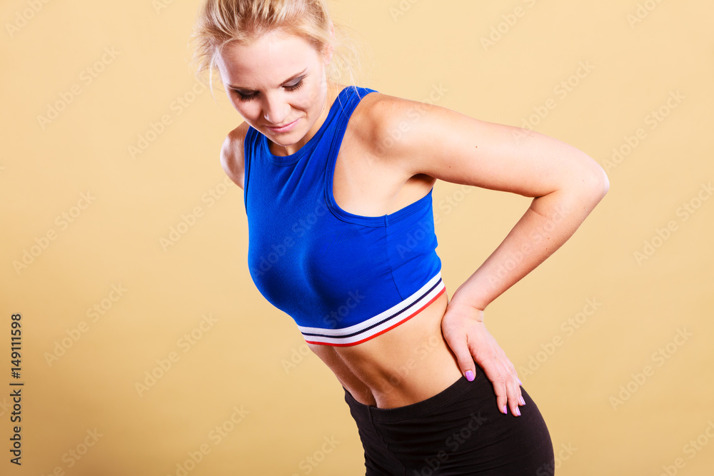 Fit woman suffering from back pain Fit woman suffering from back pain