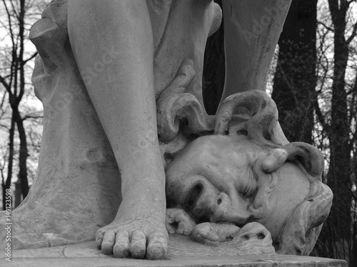 Marble statue of legs at man's head with snakes black and white 