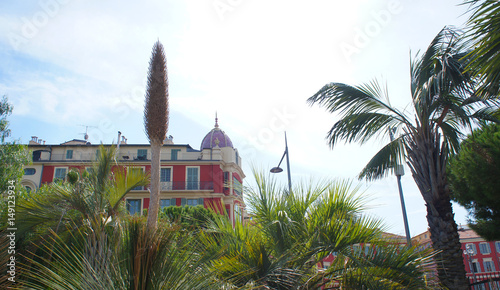 Cityscape of Nice, France view to red building and palm trees 