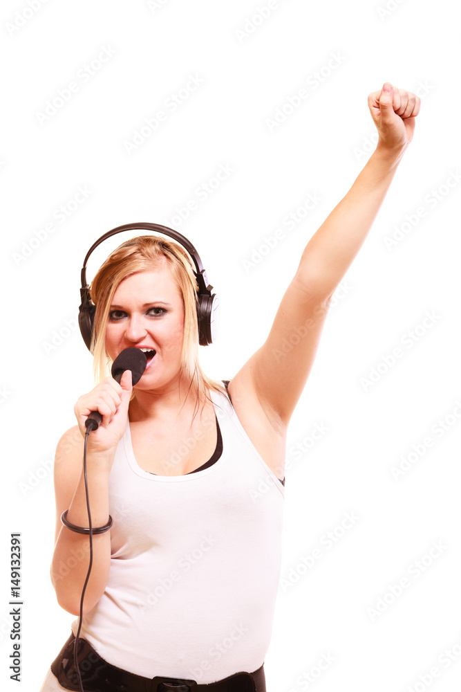 Fototapeta premium Woman singing to microphone wearing headphones