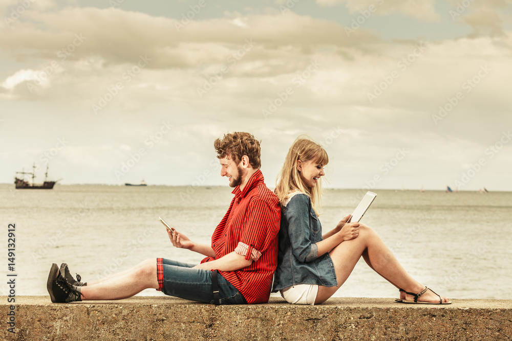 woman with smartphone man with tablet couple outdoor