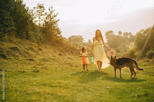 mother walk with his little daughter, and their dog