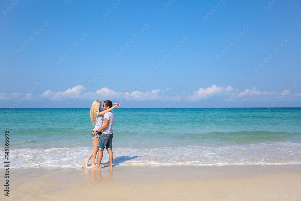 Young happy couple on beach smiling holding around each other. Love story Young happy couple on beach smiling holding around each other. Love story