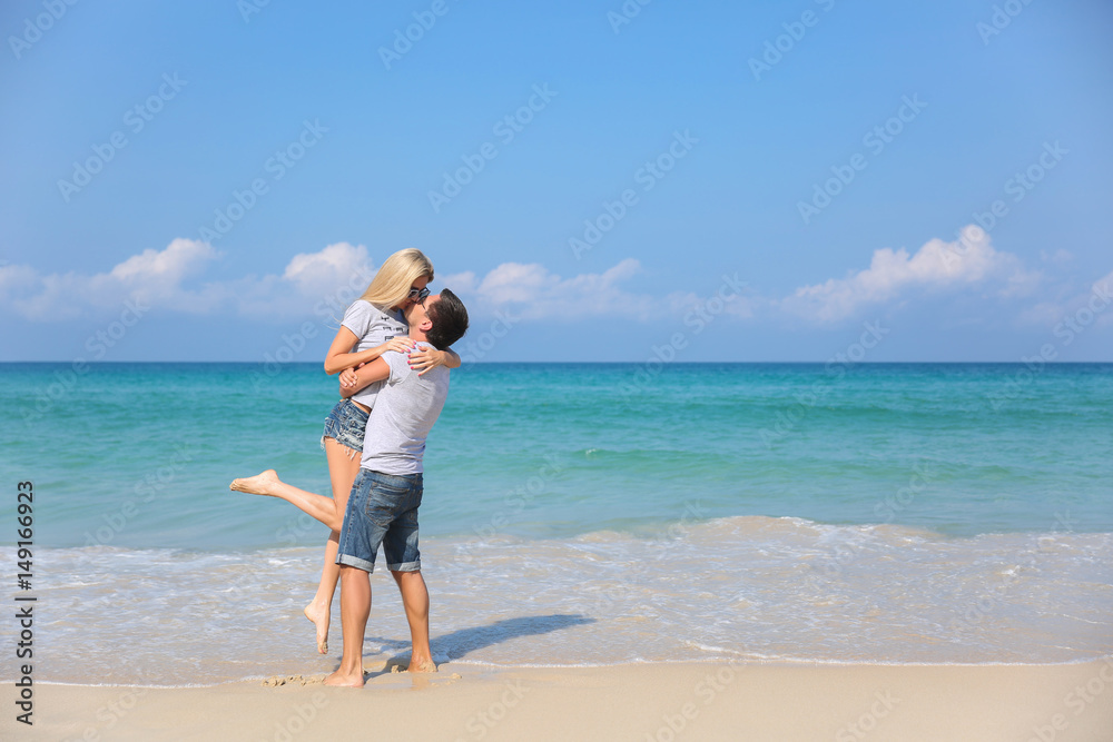 Young happy couple on beach smiling holding around each other. Love story Young happy couple on beach smiling holding around each other. Love story