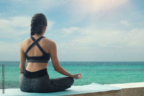young woman practicing yoga on the beach vintage tone concept relax in nature with holiday time.