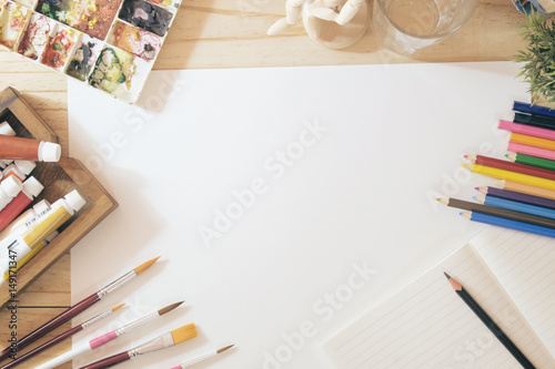 Hero Header Concept a desk of artist color pencils and paper on wood table with vintage tone photo