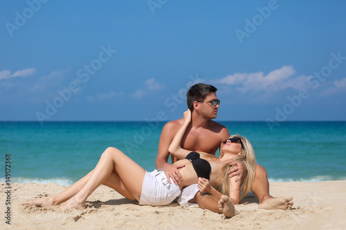 Outdoor pretty beautiful young couple in love having fun in hot weather and feeling happy together on the tropical island. Posing and hugs alone on the beach. © Ilya