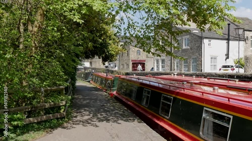 Narrow boats moored on Skipton canal next to empty towpath