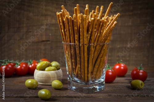 Salty sticks standing in a glass on wooden background