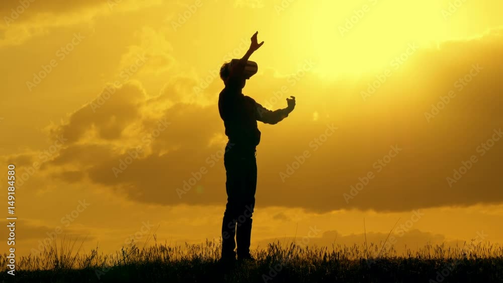 Portrait of boy with outstretched arms using vr glasses in park at sunset.Bokeh Portrait of boy with outstretched arms using vr glasses in park at sunset.Bokeh