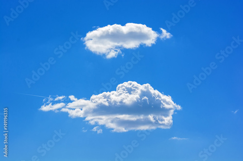 Two white clouds against blue sky