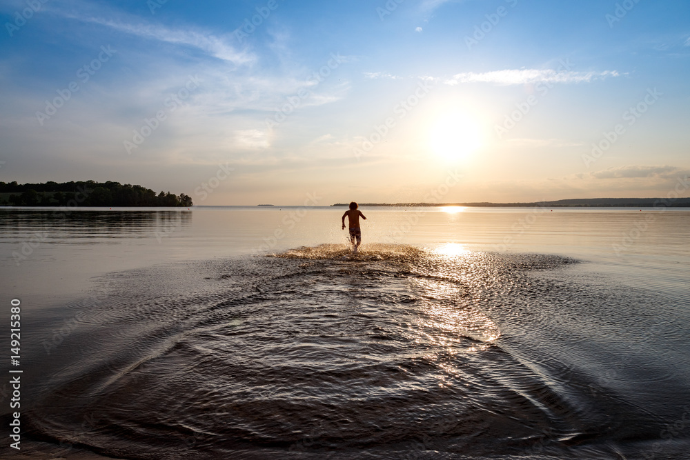 Fototapeta premium Young boy running in water