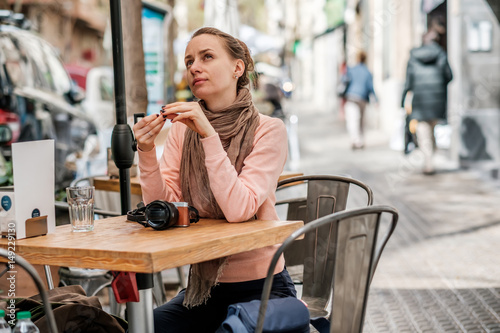 Photography Woman with camera in outdoor cafe. Barcelona, Catalonia.