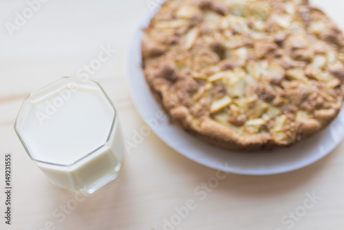 A whole apple pie and a glass of milk photo