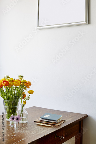 atmopsheric kitchen table fresh flowers and notebooks photo