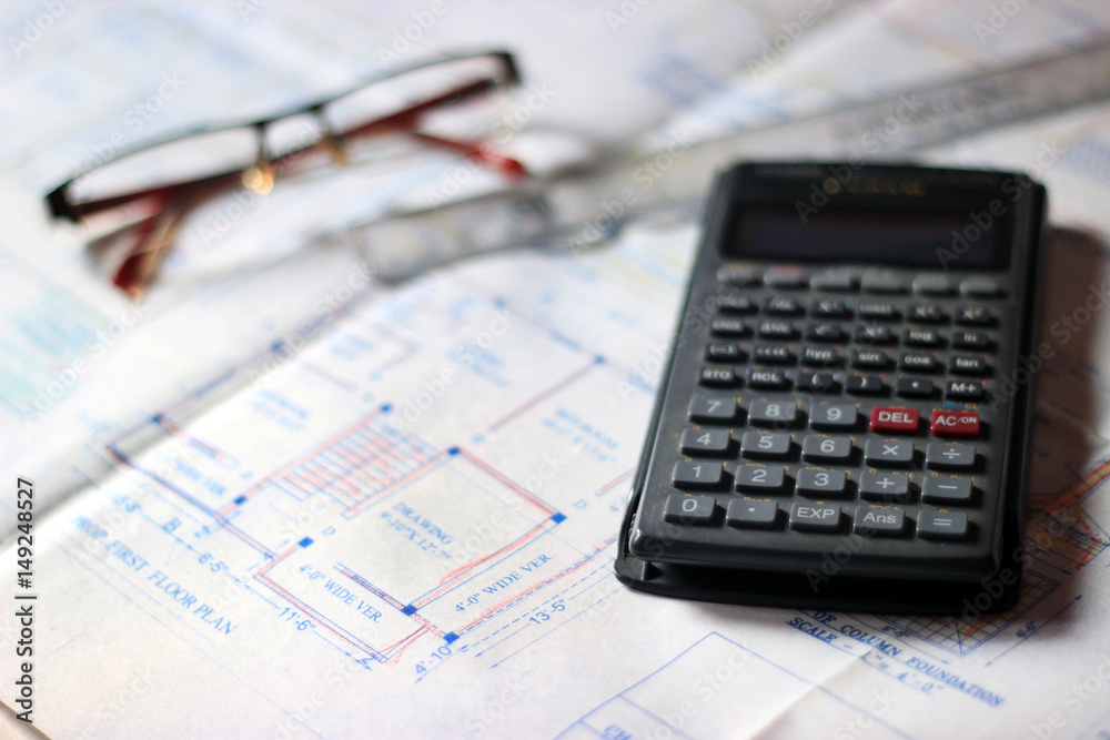 Calculator and building plans. Building planes for a new house, isolated. Calculator and building plans. Building planes for a new house, isolated.