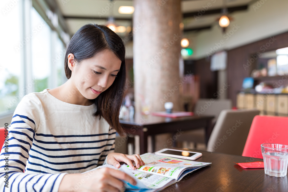 Woman reading magazine in coffee shop Woman reading magazine in coffee shop