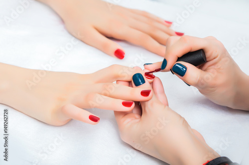 Girl has a manicure and paint nails with lacquer in the beauty salon