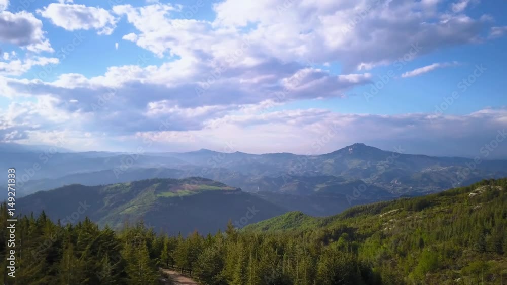Flying with a drone over mountains and forest at dusk in a beautiful natural landscape Flying with a drone over mountains and forest at dusk in a beautiful natural landscape