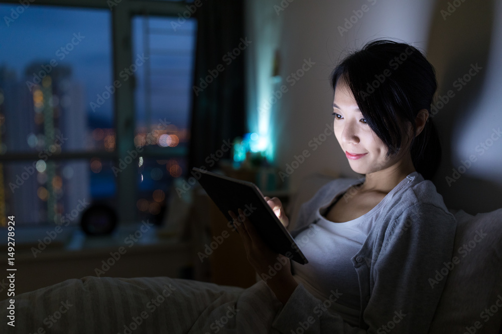 Woman use of tablet computer at night Woman use of tablet computer at night