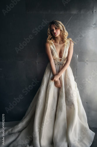 Fashion model in long dress on the metal background